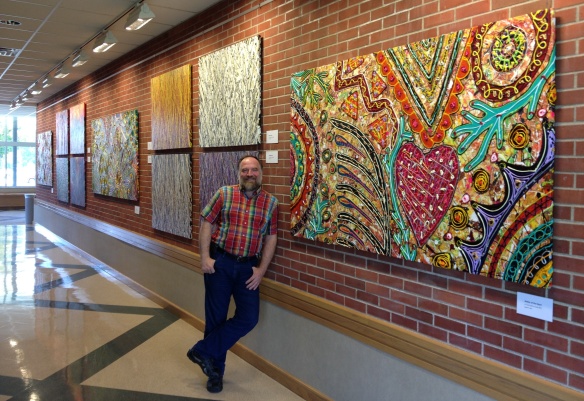 Robert F Allen with his 4x8 ft 2013 acrylic on canvas, "Matter of the Heart" and other paintings in his Manchester University exhibit.